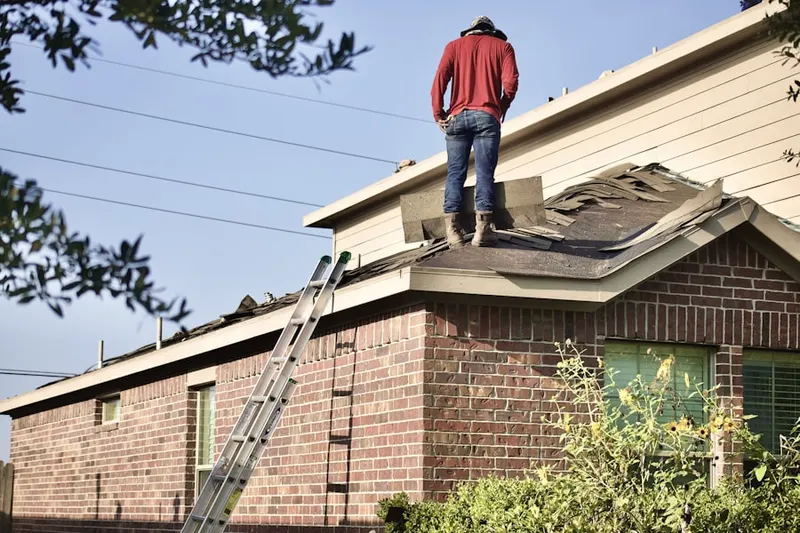 Professional roofer working on a residential roof in Green